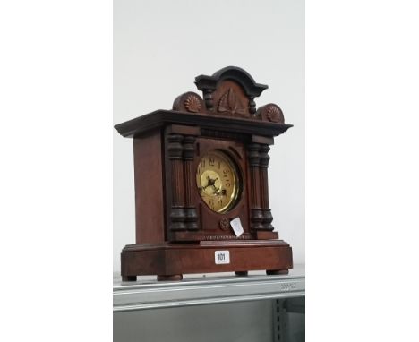 An early 20th century stained wood cased mantle clock with pillar decoration.