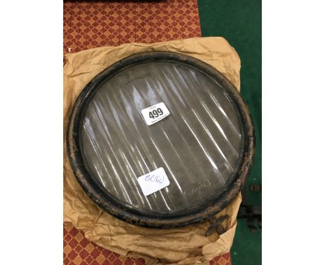 A Model T Ford automobile glass and metal headlight cover.