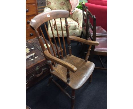 A large oak stick back armchair resting on tapered supports.