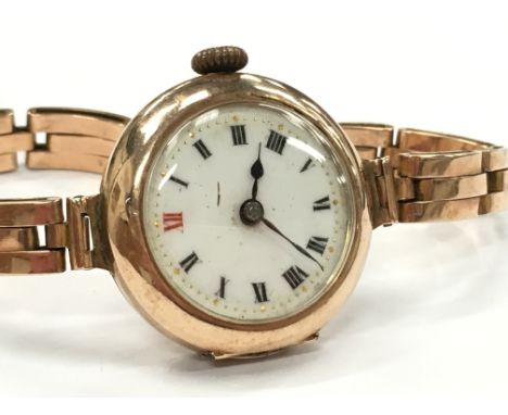 A ladies 9ct gold cased wristwatch, white enamel dial, roman numerals on 9ct gold strap (21.9g overall).