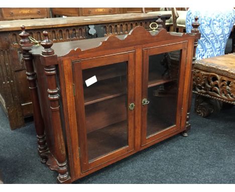 A large mahogany smoker's glazed cabinet with column supports to sides and interior fitted shelf.