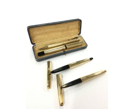 A vintage gold coloured fountain pen set in original hard case together with two gold coloured Parker fountain pens.