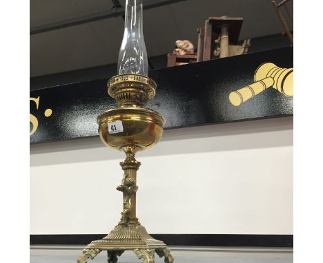 A brass oil lamp decorated with a Cherub attached to column base with clear glass funnel.