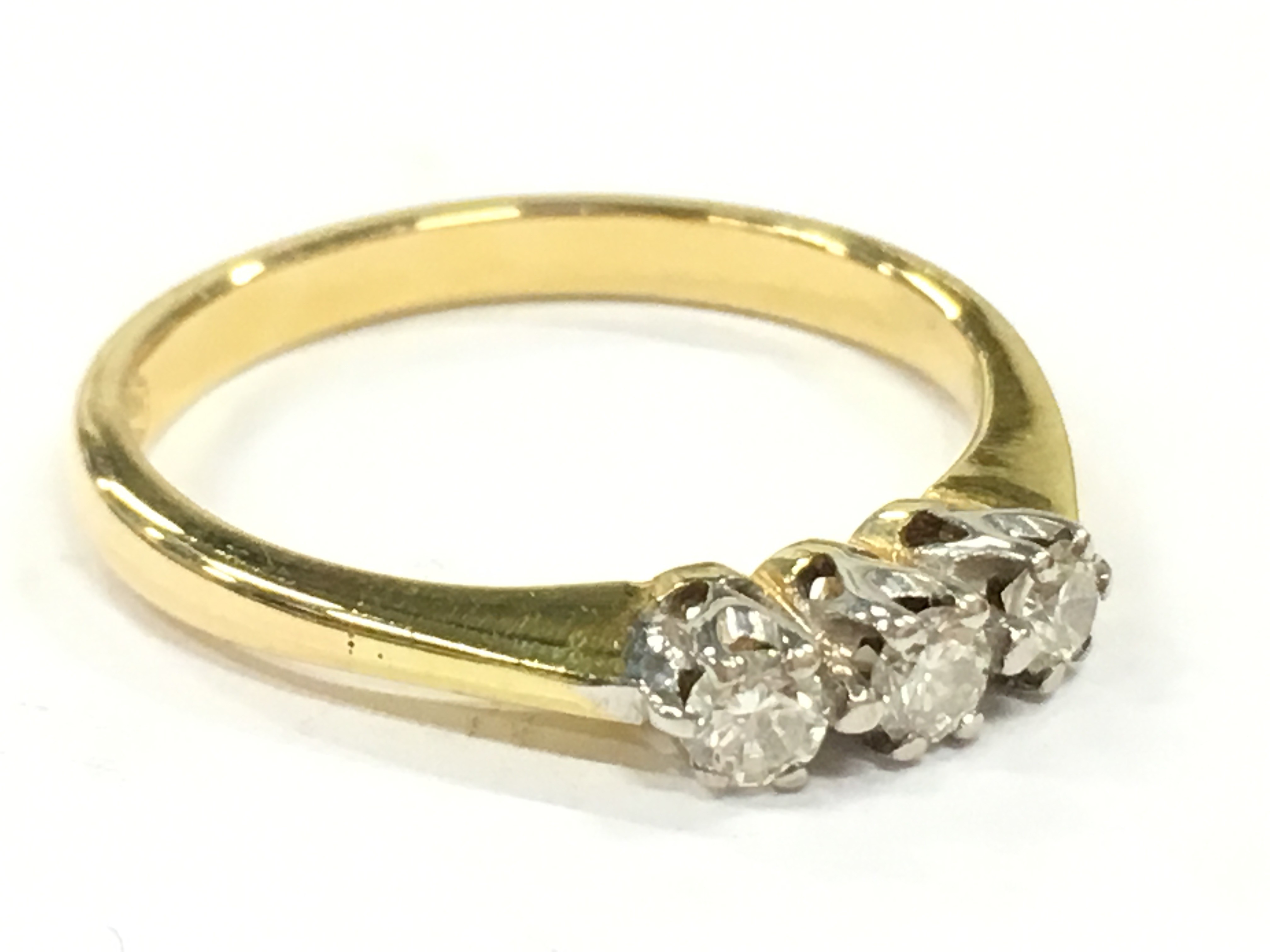 An 18 carat gold three stone diamond ring. (R10)