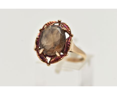 A 9CT GOLD SMOKY QUARTZ RING, designed with a claw set, oval cut smoky quartz, within an openwork surround, leading onto a po