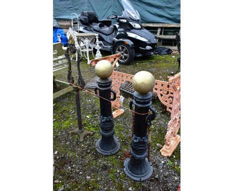 A PAIR OF CAST IRON PILLAR POSTS, with a gold painted finial, height 82cm with rusted chains, along with a cast iron balance 