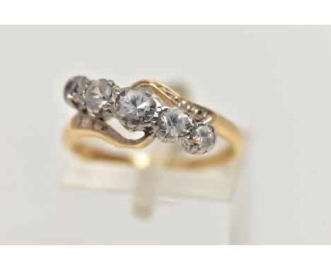 A YELLOW METAL GEM SET RING, designed with a row of five graduated colourless spinels in a white metal mount, between crossov