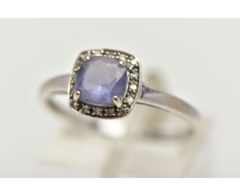 A WHITE METAL IOLITE AND DIAMOND CLUSTER RING, designed with a square cut iolite within a surround of single cut diamonds, le