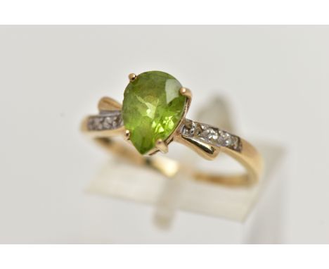 A 9CT GOLD, PERIDOT AND DIAMOND RING, designed with a four claw set, pear cut peridot, flanked with single cut diamond detail