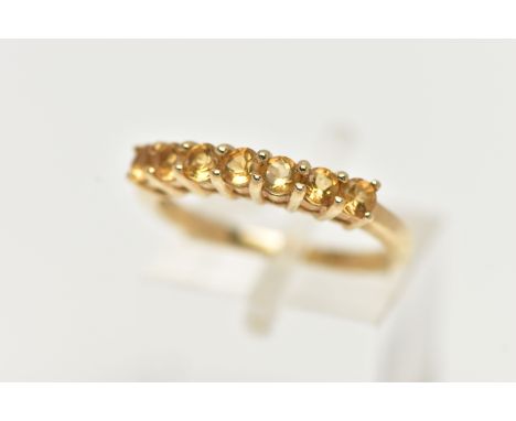 A 9CT GOLD CITRINE RING, designed with a row of seven circular cut citrines, to the polished band, hallmarked 9ct Birmingham,