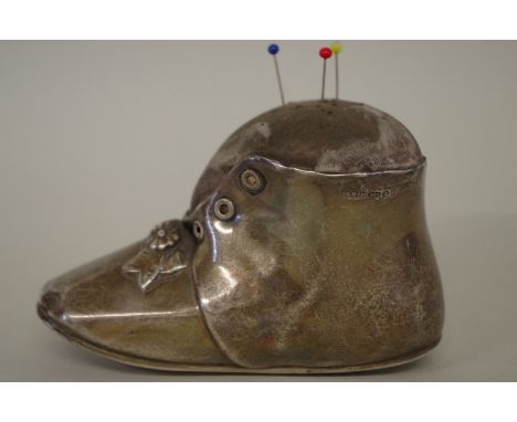 A sterling silver novelty babies boot pin cushion,&nbsp;import mark for 1906, 11cm x 7cm (including cushion). 