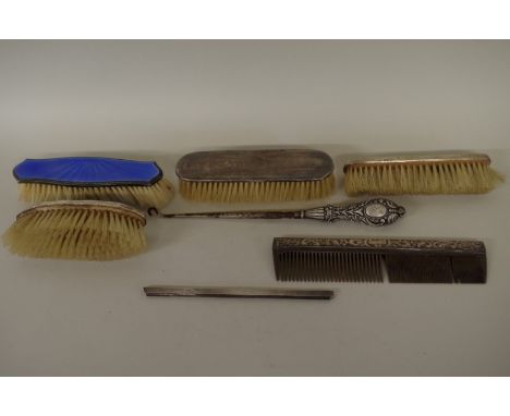 Four various silver brushes; together with two silver comb slides; and a silver handled button hook. (7) 