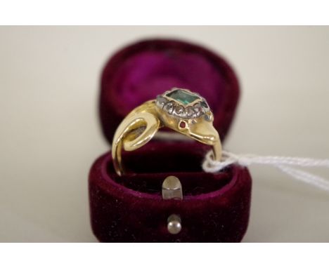 An unmarked yellow metal coiled snake ring, the head set Georgian emerald and diamonds, with ruby eyes. 