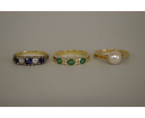 An 18ct gold emerald and diamond ring; a similar sapphire set example; and an 18ct gold pearl ring. 