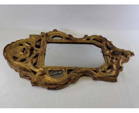A 19th Century flame mahogany wall mirror,  with foxing to the glass, 48cm x 31cm, together with a giltwood example with scro