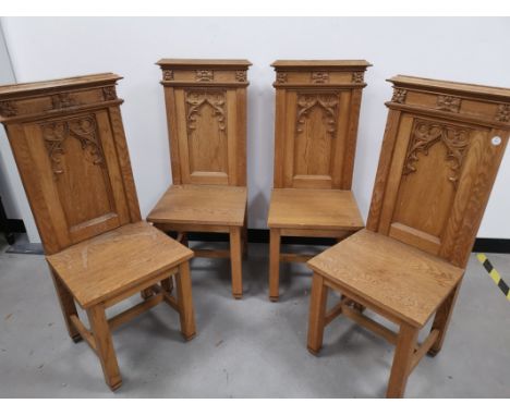 Four oak single Gothic side chairs, with carved arch decoration to the back rests.