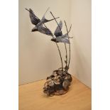 A large Gordon H Griffiths patinated metal study depicting swallows in flight above brambles,