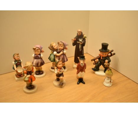 A group of seven Goebel figures comprising 'St Francis', 'Which Hand' number 258, 'Telling Her Secrets' number 196 and 'Schoo