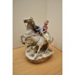A vintage porcelain figure group depicting lady and gent on horseback, having markings to