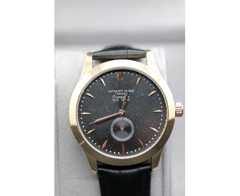 New boxed Anthony James yellow metal wristwatch on a leather strap. P&amp;P Group 1 (£14+VAT for the first lot and £1+VAT for