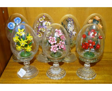 Seven Franklin Mint House of Fabergé clear glass pedestal eggs, each with enamel floral spray and simulated pearls, engraved 