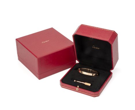 A CARTIER GOLD 'LOVE' BANGLE
Decorated with screwhead motifs, signed and numbered YD 0068, marked 750,
Size 17, 
With screwdr