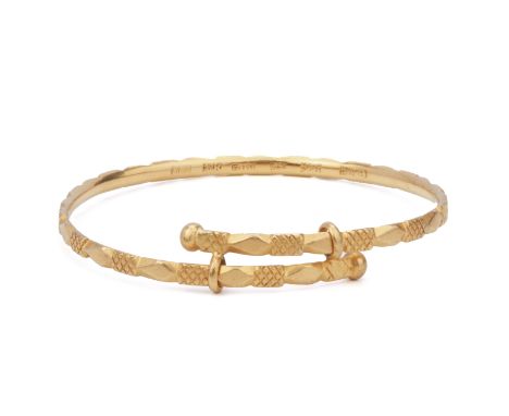 A GOLD BANGLE
The adjustable gold bangle marked '22k' to the inner side, accompanied with various hallmarks including several