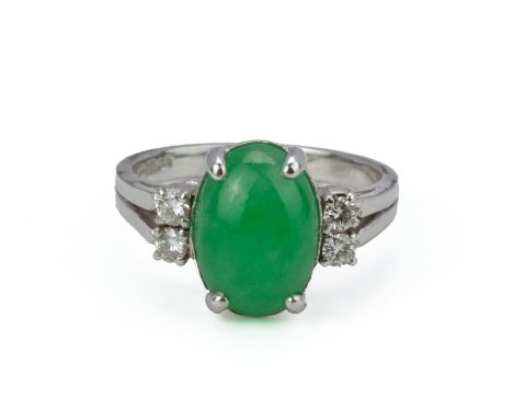 A JADE AND DIAMOND RING
To be sold at no reserve
The oval jade cabochon flanked by round brilliant cut diamonds, in white gol