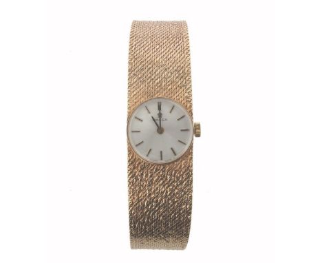 A lady's yellow gold wristwatch with circular dial signed 'Omega', on an integrated 9ct yellow gold strap bracelet. Manual wi