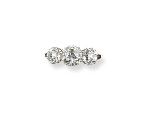 A diamond three-stone ring, the three old circular-cut diamonds are set in platinum coronet mounts and yellow gold shank. The