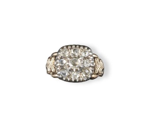 A George III diamond cluster ring, the square-form ring set with nine rose cut diamonds in silver and gold. Foliate bifurcate