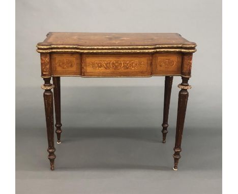 A Louis XVI style marquetry game table. Musical instrument, sheet music, and scrolling acanthus marquetry top. Ormolu mounted