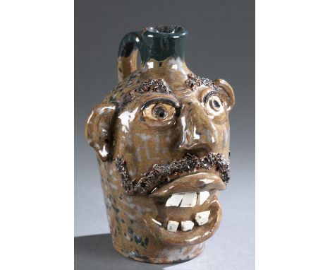 Folk art glazed ceramic face jug. 20th century. Applied ears and teeth. Dark glazed mustache and eyebrows. Signature on botto