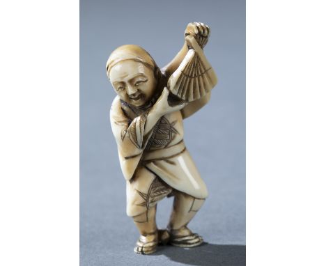 An ivory netsuke of a standing man holding a fan. Late 19th century. Unsigned. H: 4.4cm.Condition: Scratch in robe above left