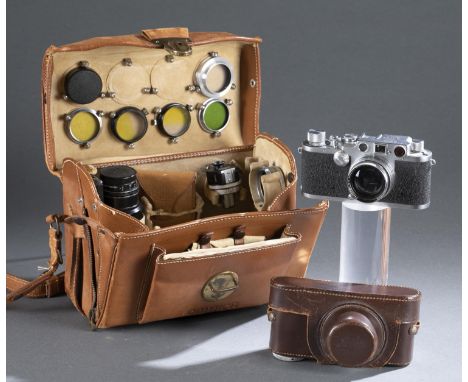 A Leica film camera, carrying case, and accessories. ++ Leica IIIc Serial no. 438679. 1945-1951. Screw mount Summitar 5cm len