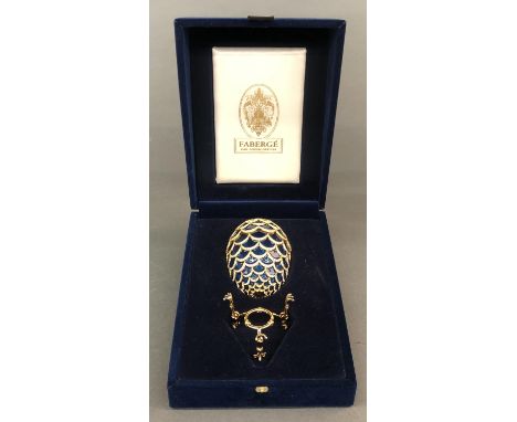 A Faberge blue pine cone egg. Two part egg composed of overlapping enameled disks and studded with crystals. Inside is a meta