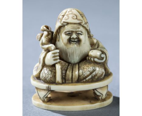 An ivory netsuke of a seated Jurojin on a low table holding a staff and a peach. 19th century. Signed Gyokusui. H: 3.6cm.Cond