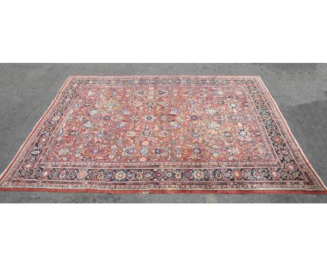 A Persian Sarouk rug. 20th century. Made in Iran. Hand-knotted wool blend. Central field of stylized geometric, floral, and v