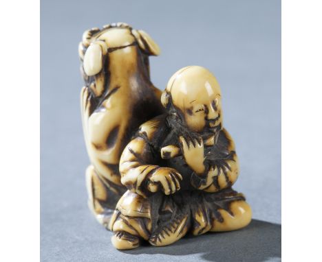 A marine ivory netsuke of two entertainers, one wearing a shishi mask and one playing the flute. Mid 19th century. Unsigned. 