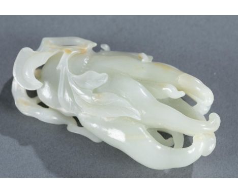 A carved celadon jade Buddha hand fruit. Celadon jade with brown inclusions. 3 7/8" x 2" x 7 /8". Condition: Chip to top leaf