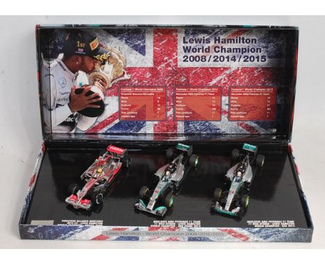 A Minichamps 1/43 scale Lewis Hamilton World Championship three piece boxed set, model No. 412081415, in the original all-car