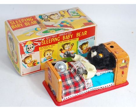 A Yonezawa tinplate and battery operated sleeping bear, in original all-card box, with alarm clock attachment