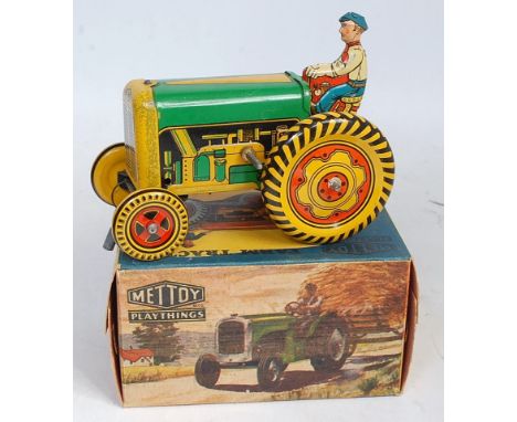 A Mettoy No.6435 tinplate and clockwork mechanical farm tractor, comprising green, red and yellow tin-printed body, with orig