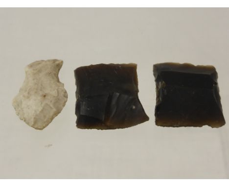 Two Stone Age cutting and skinning flints together with an arrow head.