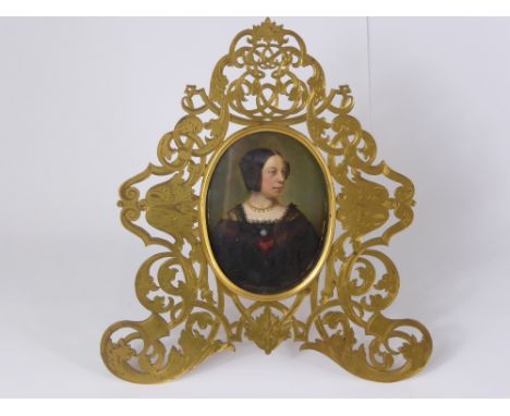 An Oval Portrait Miniature Oil of a Lady, the portrait depicting a distinguished lady, presented in a Victorian brass fretwor