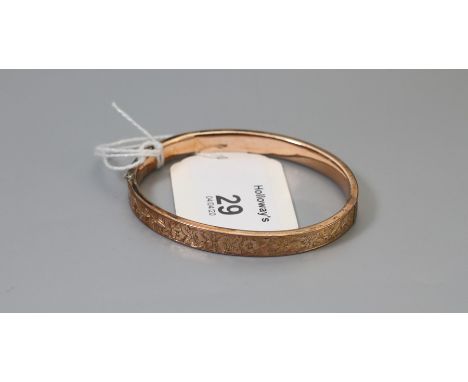 A late Victorian 9ct rose gold bangle, foliate engraved to front, push button concealed clasp, Birmingham 1894,  some dents t