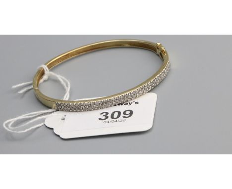 A diamond set bangle, the front set with a double row of brilliant cut diamonds to a push button clasp, marked '14k',  13.4g