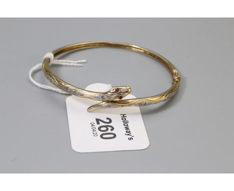 A 9ct gold snake bangle, with engraved diamond set panels to body and cabochon ruby eyes,  10.4g