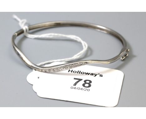 A diamond set bangle, the undulating bangle stamped '9k' with graduated diamond set to centre, 6.3g
