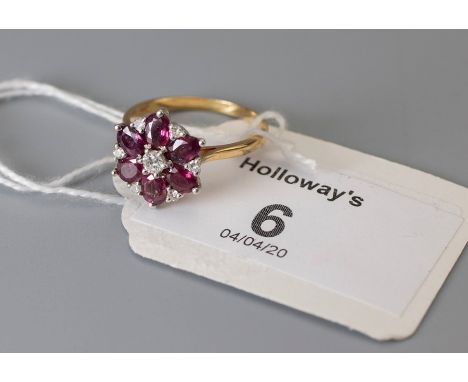 A ruby and diamond cluster ring, with five oval cut rubies around a single central brilliant cut ruby with diamond detail, to